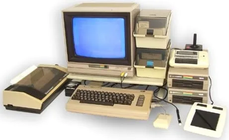 Commodore 64 desk setup with 1541 disk drive, monitor and peripherals
